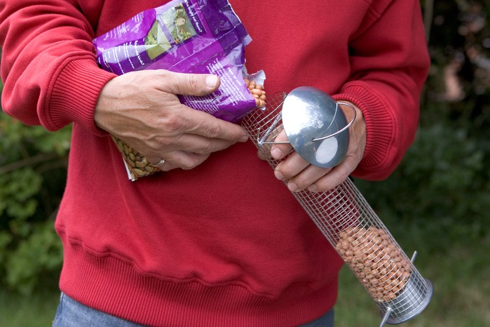 Refilling a bird feeder Refilling a bird feeder