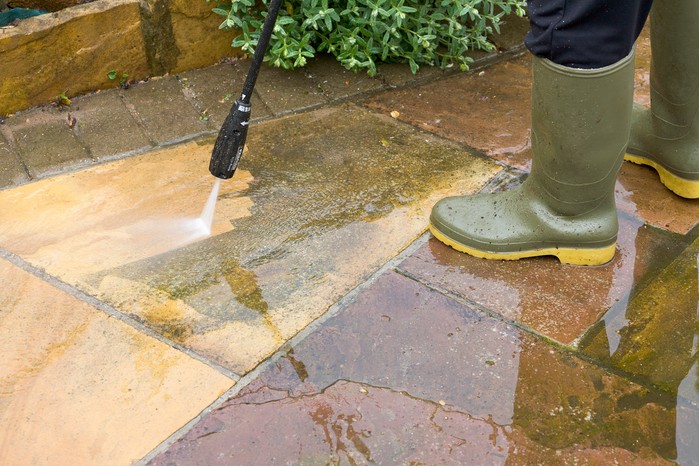 Using a pressure washer to clean a patio. Getty Images Using a pressure washer to clean a patio. Getty Images